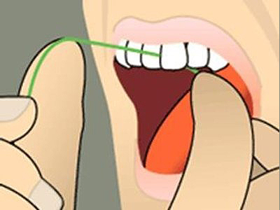 Hands demonstrating mouth opening technique with orange tongue depressor for dental examination.